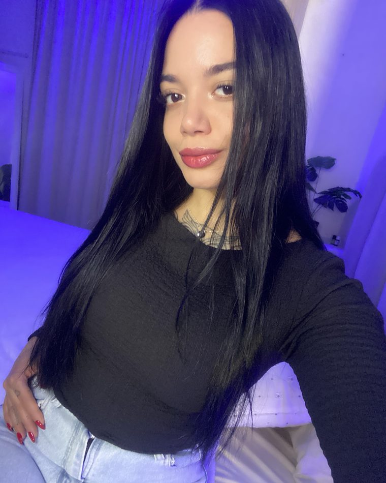 Elena de pie en su habitación, luz morada de fondo